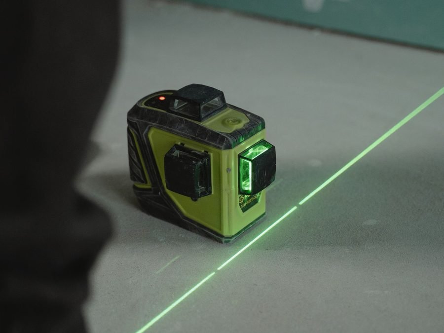 Télémètre laser en action sur un chantier, prise de mesures pour un projet d'aménagement